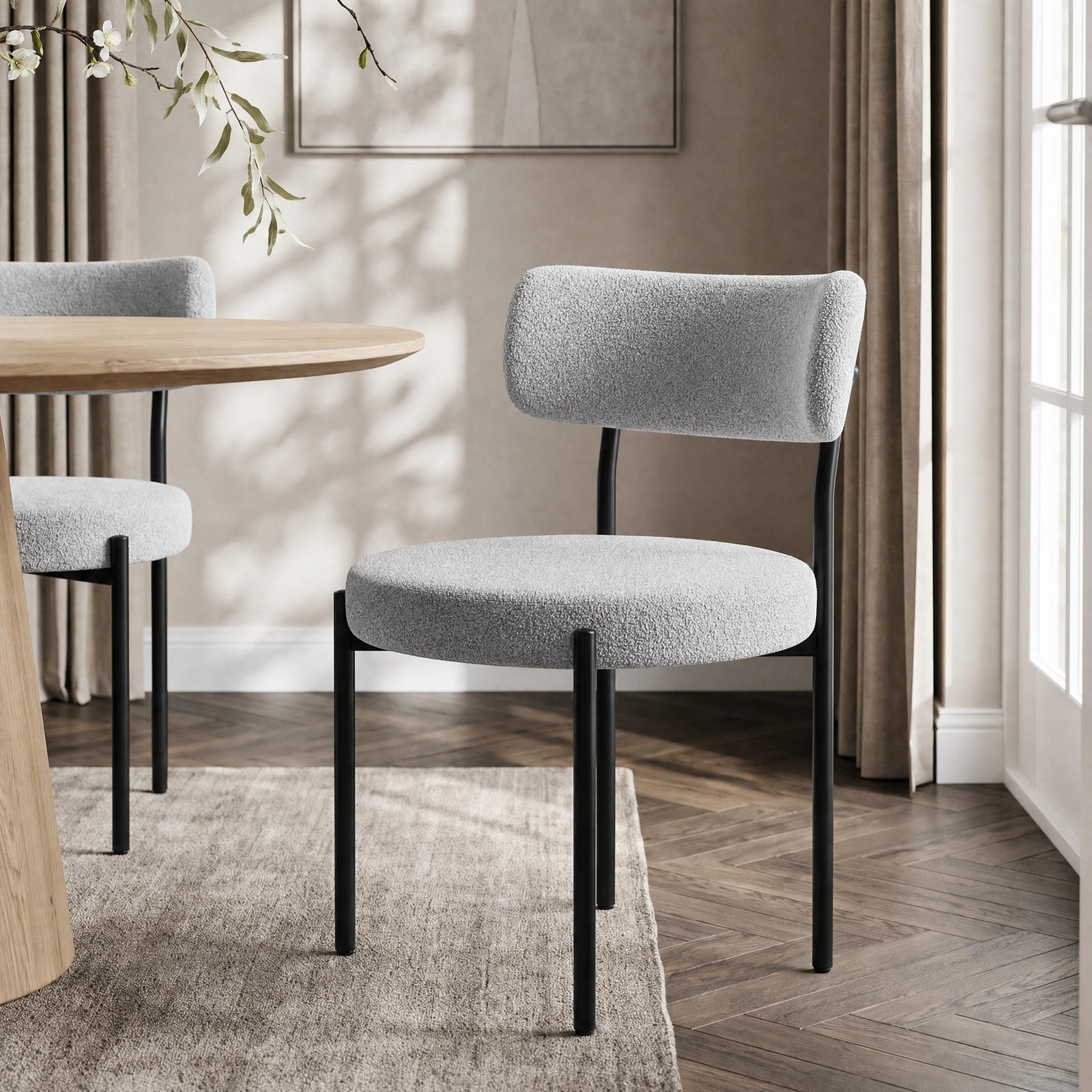 [Light Grey | Set of 4] Boucle dining chair beside a round table, showing curved back and slim black legs.