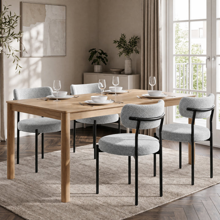 [Light Grey | Set of 4] Four boucle dining chairs around a rectangular wooden dining table in a bright room.