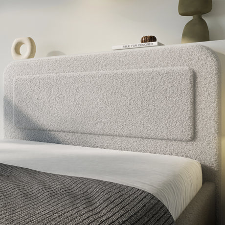 Boucle upholstered ottoman storage bed with curved headboard in soft grey fabric, showcasing modern texture and minimalist bedroom design.