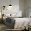 Grey boucle double ottoman bed angled, charcoal tasselled throw draped over foot of low storage base