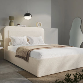 Wide angle of beige boucle king ottoman bed, gas-lift base with folded striped throw across foot