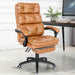 Brown PU leather home desk chair shown in a cozy office setting with soft cushion and sturdy wheels.