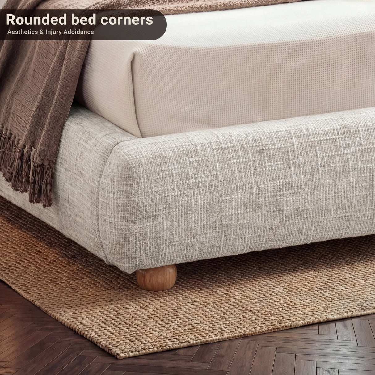 Low-angle view of the bed base corner, highlighting fabric wrap, rounded shape, and sturdy wooden feet