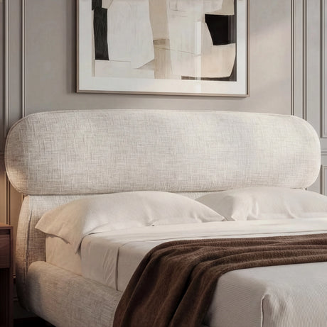 Camel upholstered headboard with smooth, curved, and dense padding visible in a modern, natural light bedroom 
