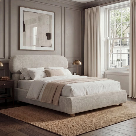 Camel upholstered king bed positioned in a spacious bedroom, styled with layered neutral bedding and warm ambient light