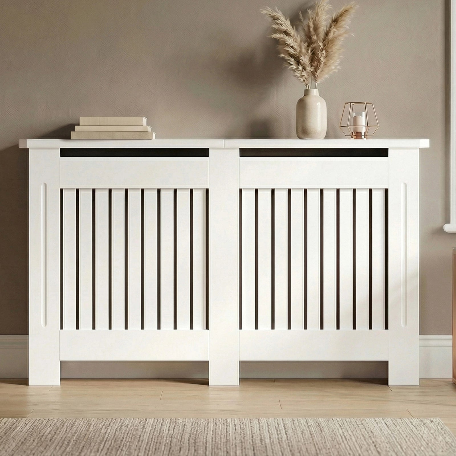 [Large] Chelsea White Radiator Cover front-facing in taupe room on wooden floor with pampas vase, stacked books, and rose gold lantern on wide dual-panel top
