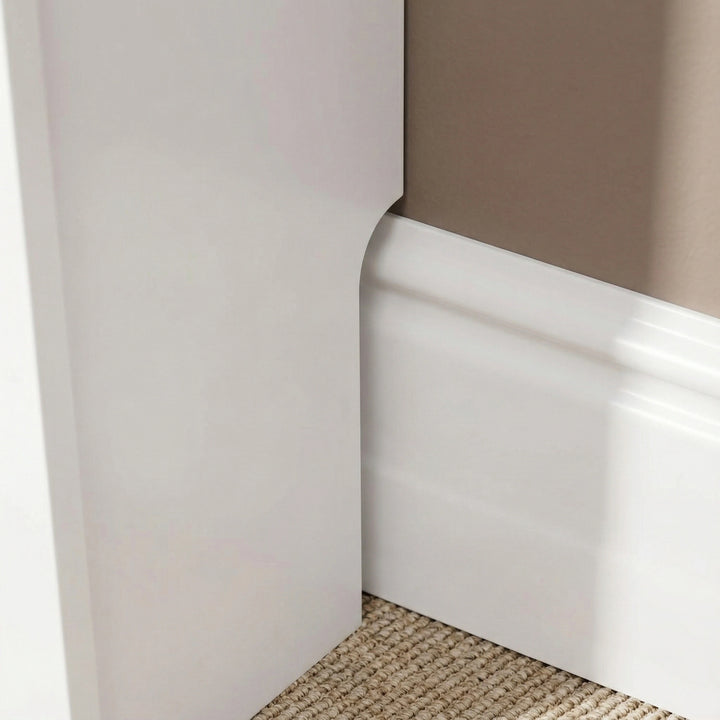 [Large] Chelsea White Radiator Cover base leg close-up showing recessed skirting board cutout allowing flush fit against a profiled wall skirting