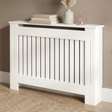 [Medium] Chelsea White Radiator Cover angled three-quarter view in taupe room on wooden floor with jute rug and rose gold accessories on top shelf