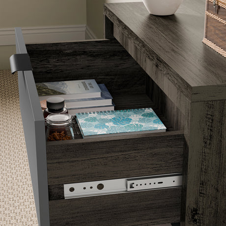 Bedroom drawers in a wooden grey finish, with the drawer open showing books, a notebook, and jars in a natural light setting