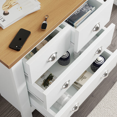 chest of drawers white tall with open drawers, storing books, perfumes, and towels.
