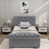 Front-facing view of light grey Chesterfield single ottoman bed, featuring plush tufted design and classic rolled edges.