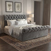 [King | Dark Grey] Chesterfield ottoman bed side angle showing scroll headboard with botanical prints on wall