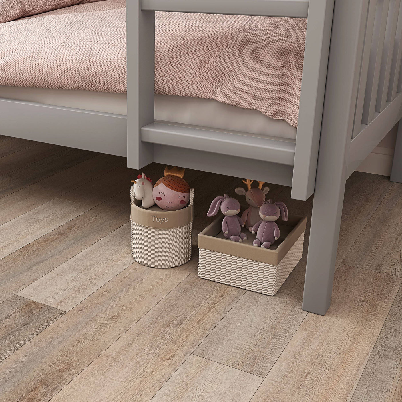 Under-bed storage area of grey bunk bed with toy baskets, perfect for organizing children's toys and maximizing space.