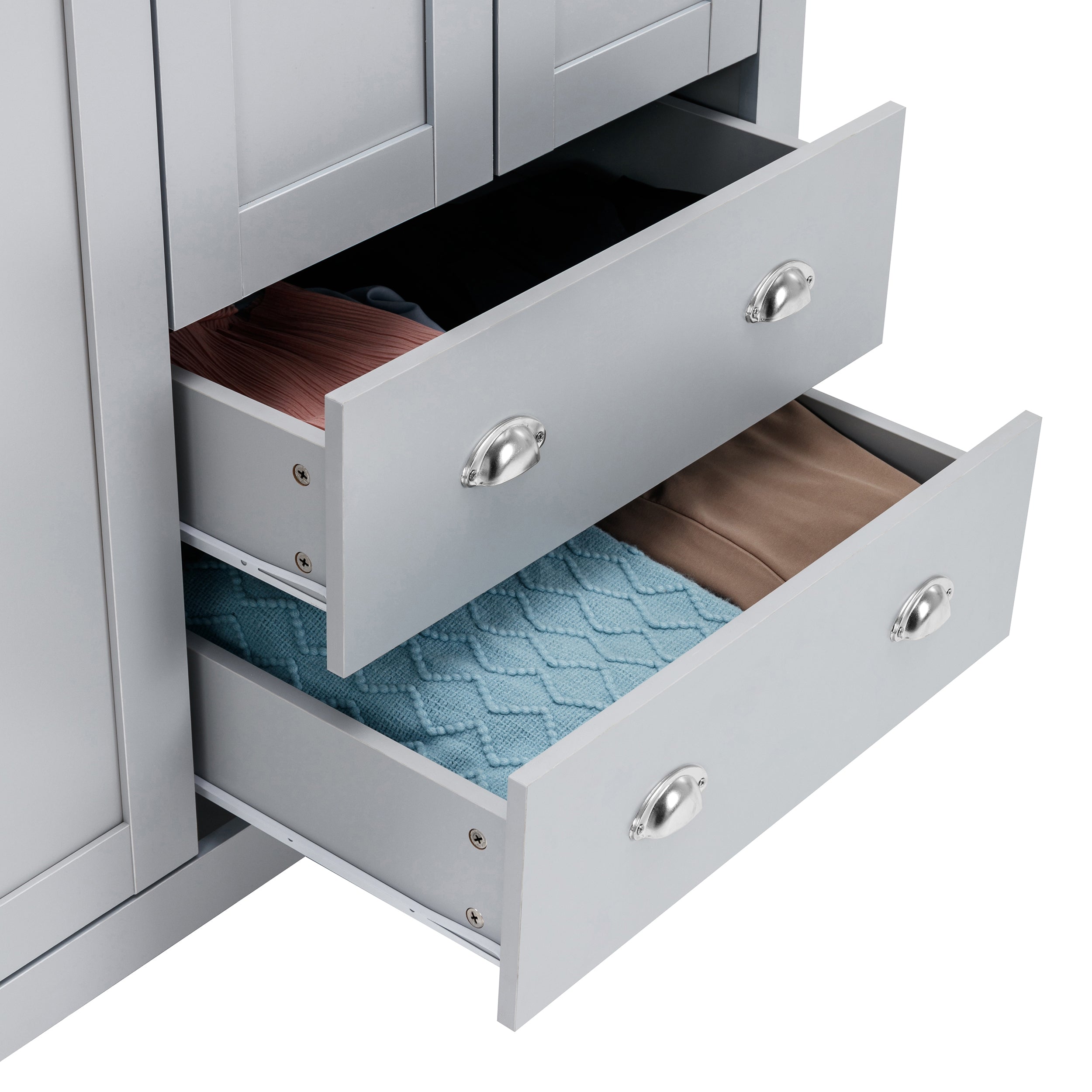 Close-up of grey wardrobe drawers open with neatly folded clothes and a blue knitted blanket.