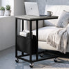 [Concrete] C-shaped side table by sofa with concrete-effect top, black frame, pouch, laptop and caster wheels