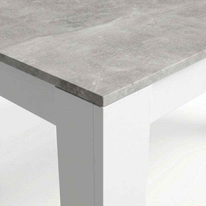 [Concrete] Close-up of the grey concrete-effect tabletop corner; the mottled top meets a thick white square L-shaped leg.