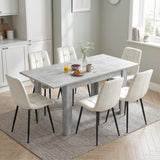 [Concrete] Extended flip-top dining table set for six with cream chairs in a bright kitchen dining area.