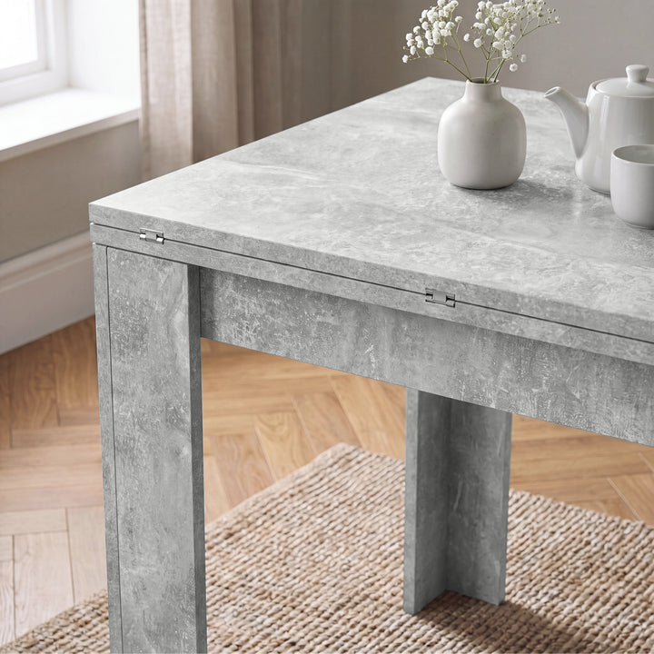[Concrete] Close-up of the folded dining table concrete tabletop, steel hinges and wide supporting legs.