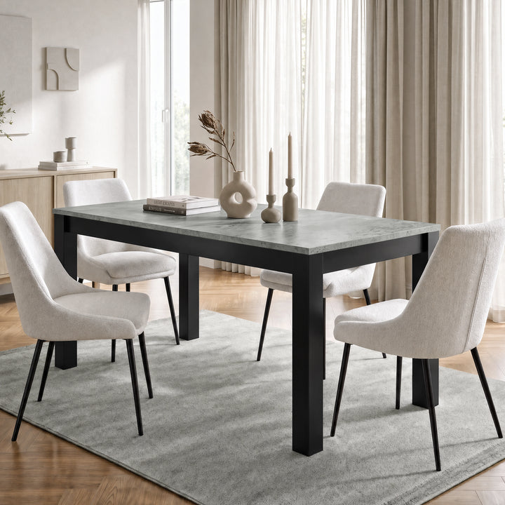 [160cm | Concrete] Closed table in bright dining room with four cream chairs, vases, candles, rug, and window light