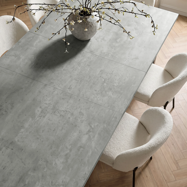 [160cm | Concrete] Top-angle view of tabletop panels with rounded vase, stems, cream chairs, and wooden floor