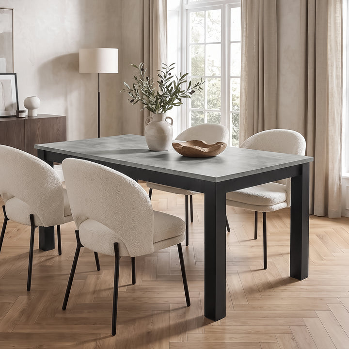 [160 cm | Concrete] Regular size 160cm extendable table with four cream chairs, leafy vase and bowl in a bright dining room.