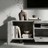 [Concrete] Kystra TV stand left compartment open, dark vase with stems on top and AV gear in centre