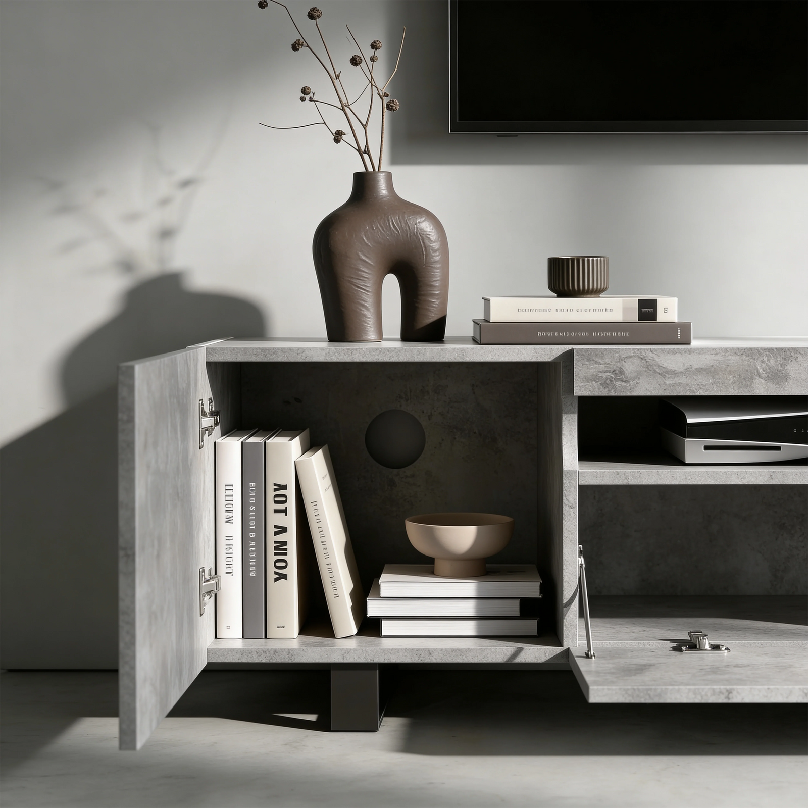 [Concrete] Kystra TV stand left compartment open, dark vase with stems on top and AV gear in centre