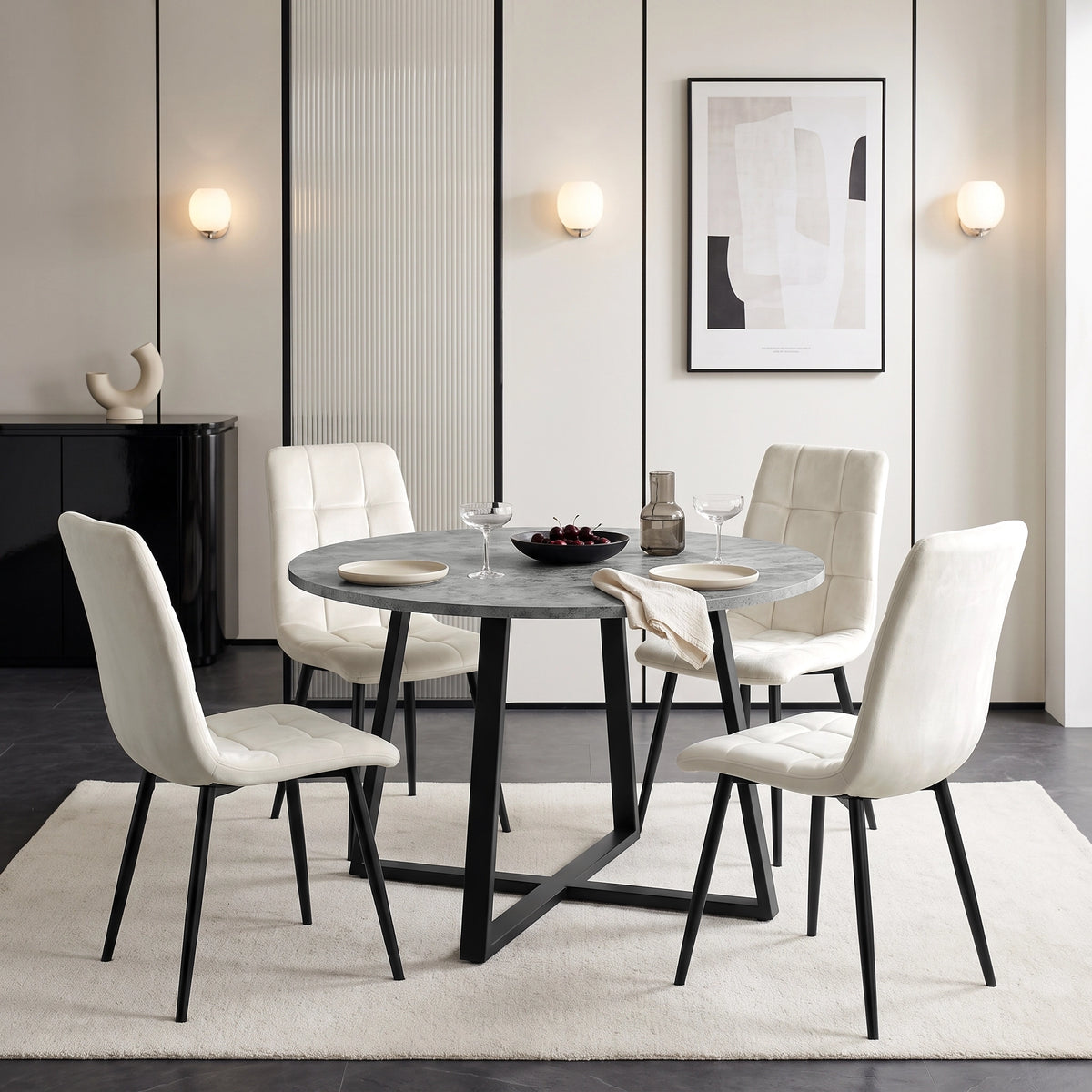 [Concrete] Round dining table set for four with plates and glasses, surrounded by white chairs on a neutral rug.