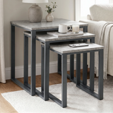 [Concrete] Stackora nest of tables set of 3 displayed in a bright living room corner with lamp, books, candle, and phone on each surface