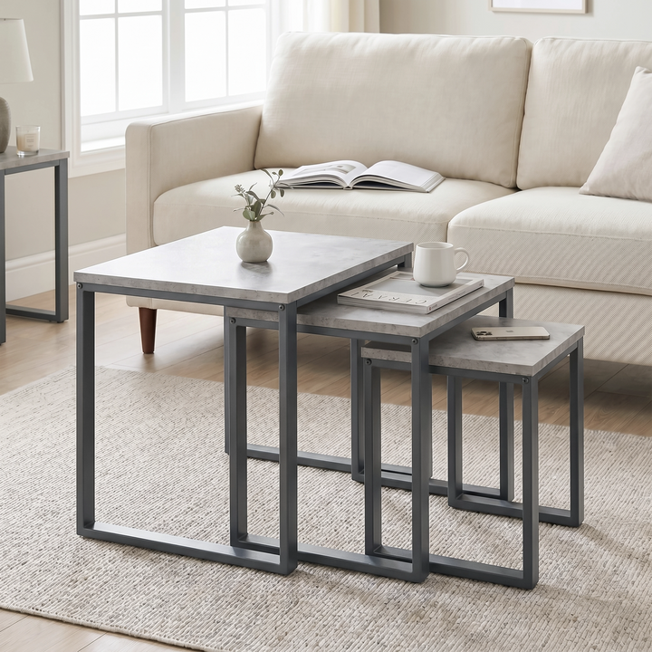 [Concrete] Stackora nest of tables set of 3 arranged in a living room with sofa, rug, vase and books styled across all three surfaces