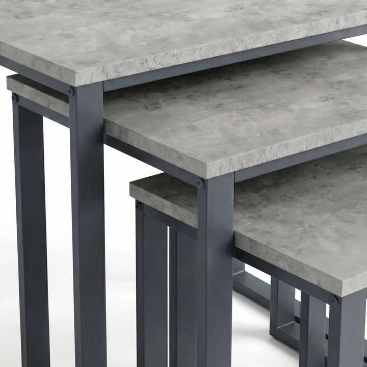 [Concrete] Stackora nest of tables close-up detail showing concrete-effect surface finish and dark grey metal corner bracket fixings on all three tops