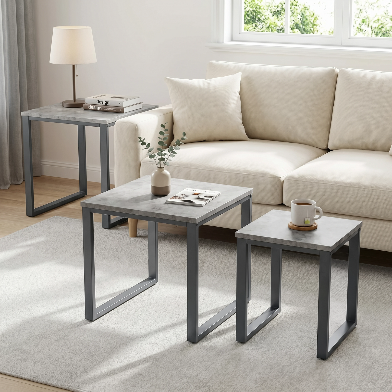 [Concrete] Stackora nest of tables set of 3 used separately across a bright living room as side table, coffee table, and accent table with lamp and plant