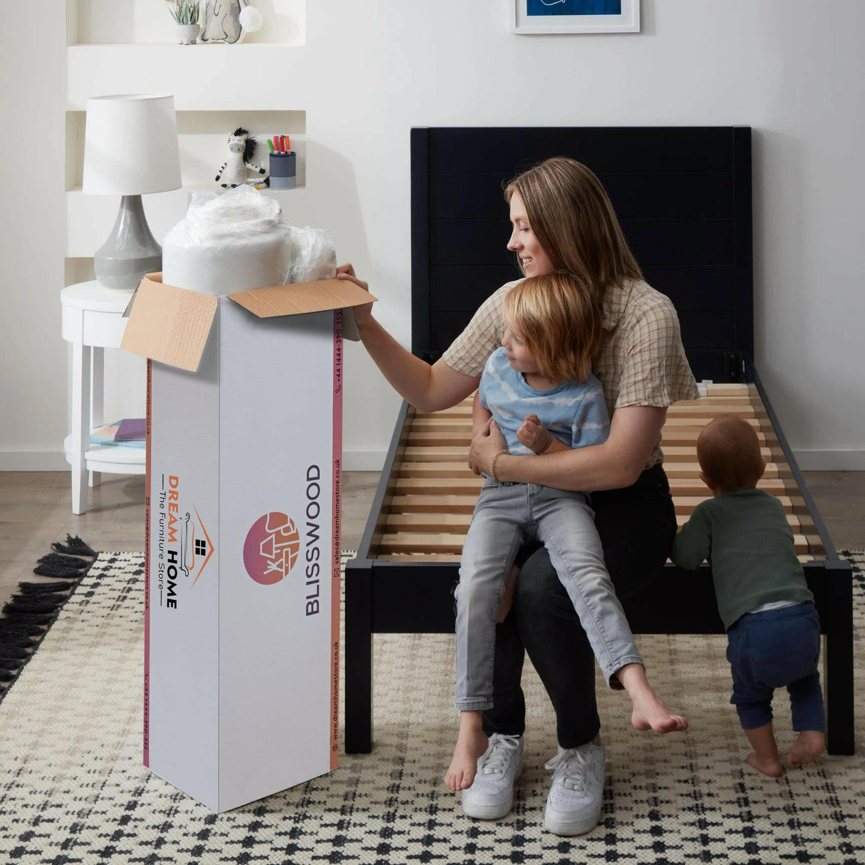 Mother with two children unpacking a Blisswood cool gel memory foam mattress full size.