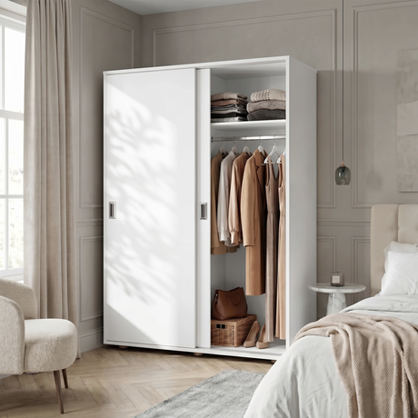 [Cool White] Torvek sliding wardrobe half-open in warm bedroom with hanging jackets, folded shelf items and basket
