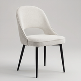 [Cream | Set of 2] Angled view of woven comfy dining chair with rounded open back, piped seat & four black metal legs.