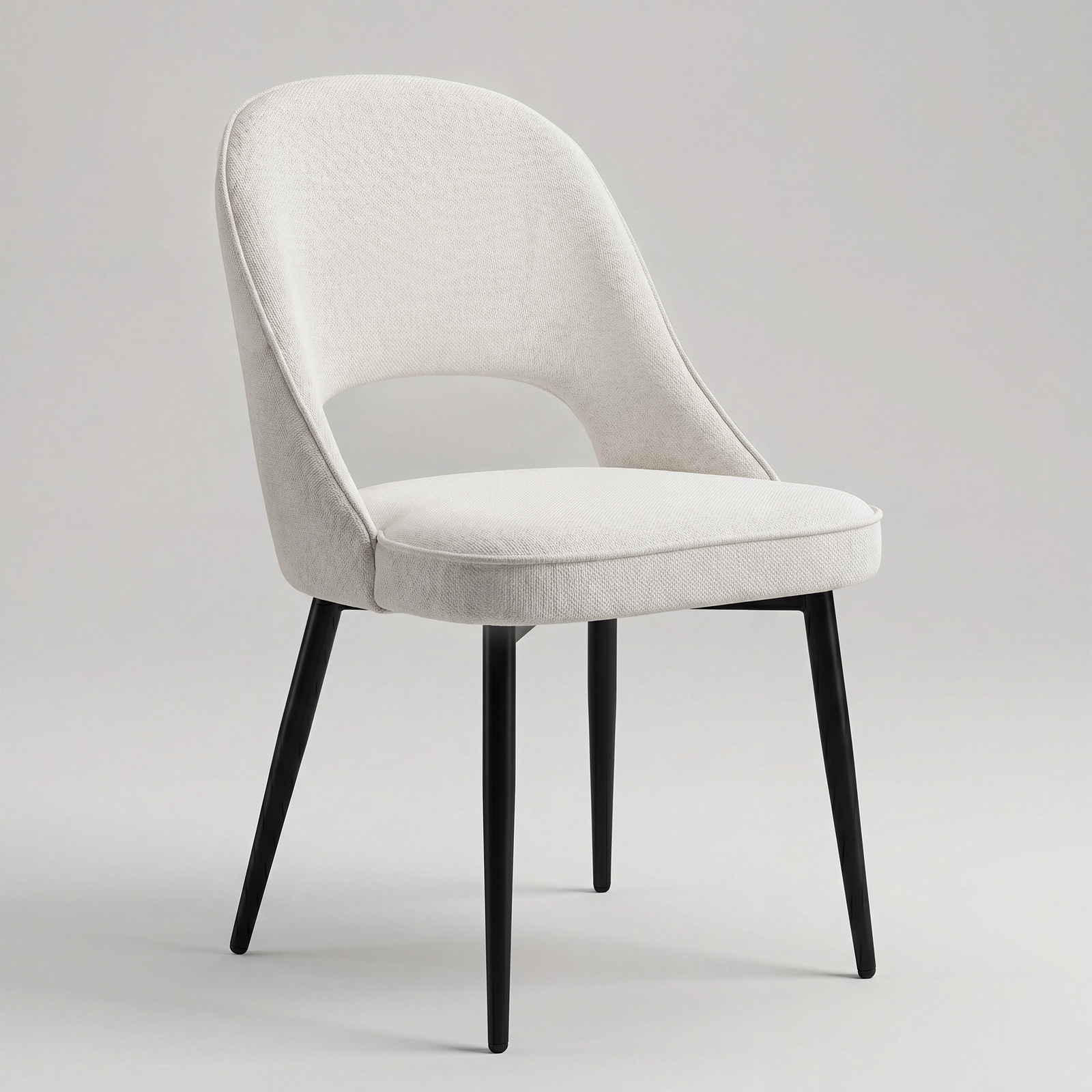 [Cream | Set of 2] Angled view of woven comfy dining chair with rounded open back, piped seat & four black metal legs.
