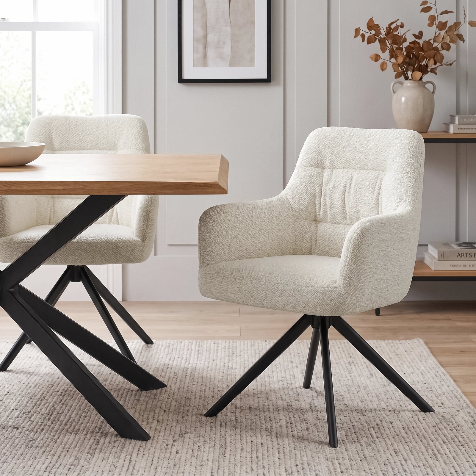 [Cream | Set of 2] Two swivel dining room chairs beside a pale wood table, featuring rounded arms and black metal base.