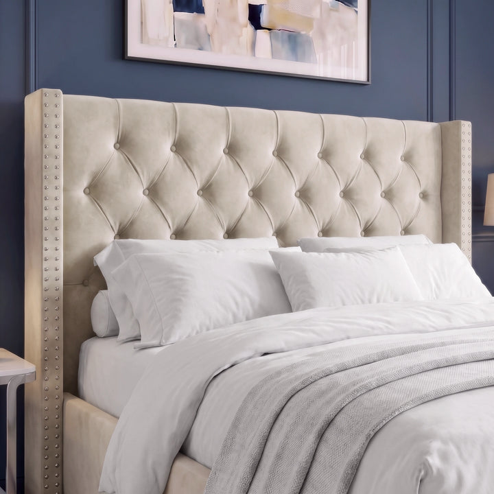 [Double | Beige] upholstered bed headboard in a warm beige fabric with diamond tufting and nailhead trim, shown on a bed with white bedding in a styled bedroom setting.