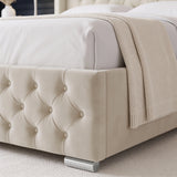 [King | Beige] close-up of a tufted upholstered bed frame in a warm cream or beige fabric, shown with white bedding and a textured cream throw blanket.