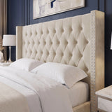 [King | Beige]A large upholstered headboard in a warm cream or beige fabric, featuring deep button tufting and nailhead trim on the side rails, shown on a bed with white bedding in a styled bedroom.