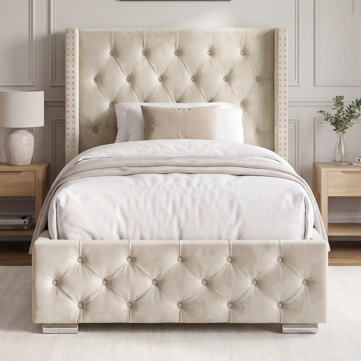 [Single | Beige] tufted upholstered bed frame with a matching headboard and footboard, styled in a neutral bedroom setting with white bedding, wooden nightstands, and wall sconces.