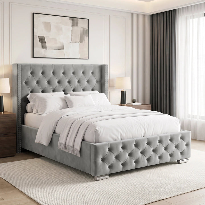 [Double | Light Grey] tufted velvet bed frame with a high wingback headboard and matching footboard, styled in a bright, contemporary bedroom with white bedding, wooden nightstands, and a large window.