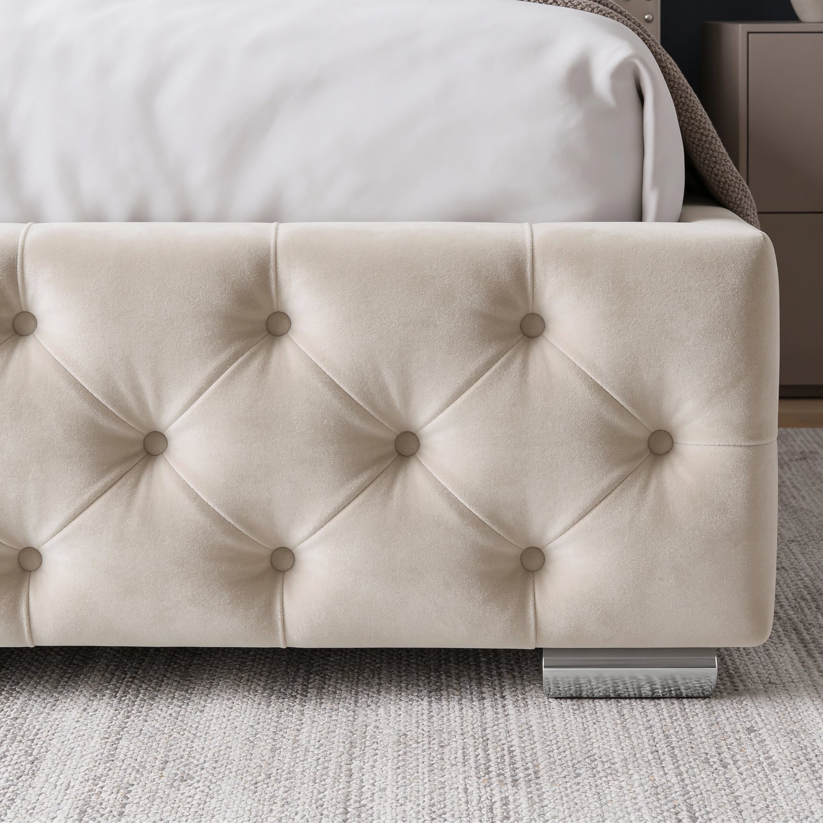 [Small Double | Beige] Close-up of a tufted upholstered bed frame in beige velvet, with a white sheet and pillow visible at the top and a gray textured rug underneath.
