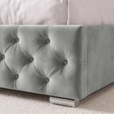 [Small Double | Light Grey] of a tufted velvet bed frame in a light grey color, resting on a textured light beige rug with white pillows visible at the top.