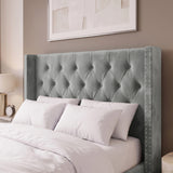 [Small Double | Light Grey] tufted velvet wingback headboard with nailhead trim on a bed with white bedding, set against a warm taupe wall with a framed print above.