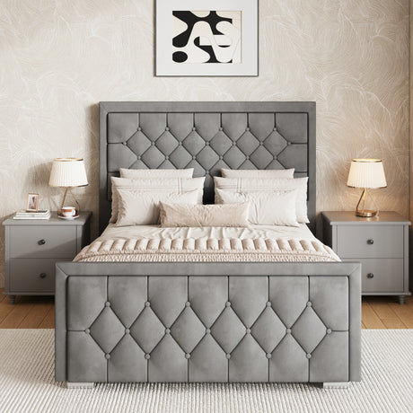 Grey upholstered ottoman bed king with a matching cross-puffed headboard and footboard placed between two bedside tables.
