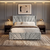 [King | Silver] King crushed velvet ottoman bed in silver shown at night, lit lamps either side of headboard