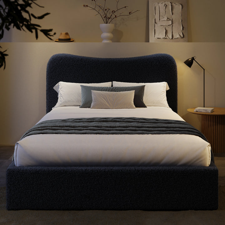 [Double | Blue] Front view of boucle ottoman bed with curved headboard in warm ambient evening lighting