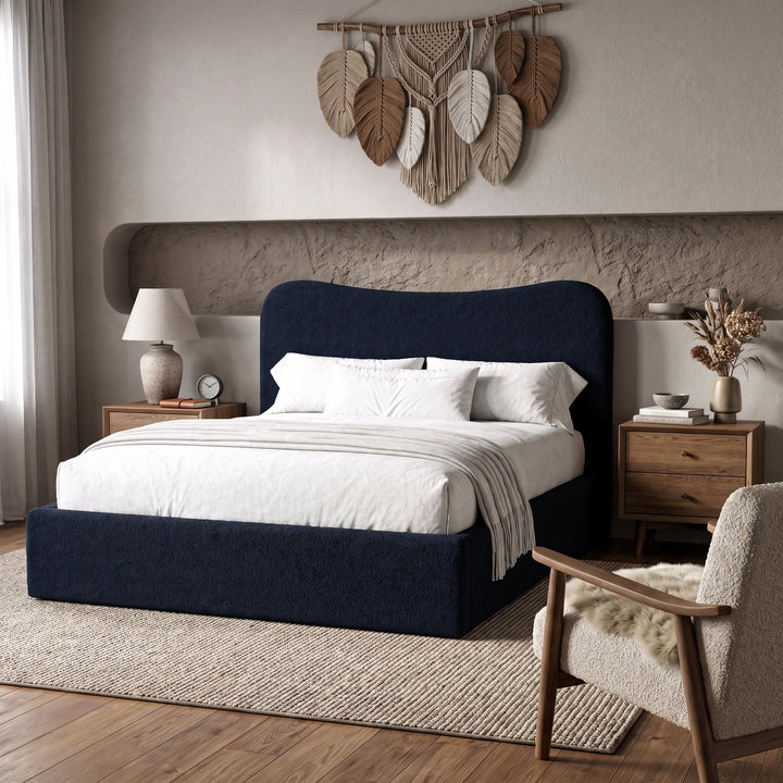[Double | Blue] Boucle fabric ottoman bed from the side with white bedding and fringed throw beside floating shelf with art