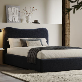 [Double | Blue] Boucle fabric ottoman bed from the side with white bedding and fringed throw beside floating shelf with art